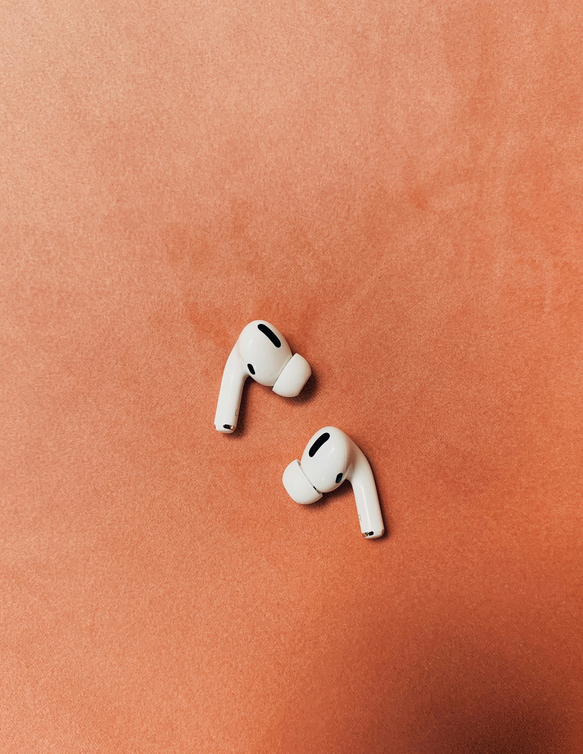 White wireless earbuds on colored background