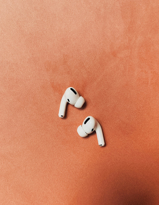 White wireless earbuds on colored background
